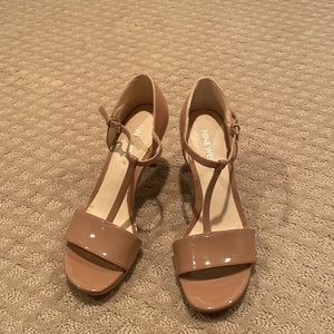 Nude patent leather Nine West T-strap heeled sandals.